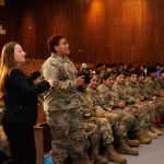 A member of the Barringer High School Junior ROTC program asks a question of the nine police officers from Puerto Rico who spoke at a special assembly.