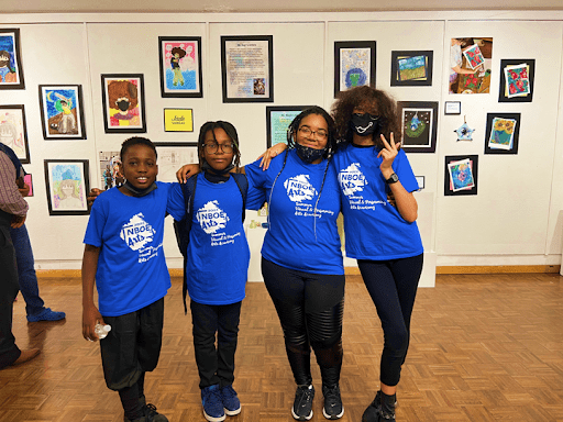 Summer Visual and Performing Arts Academy students with artwork on display at the culminating art exhibit featuring artworks created during the 5 week summer program.