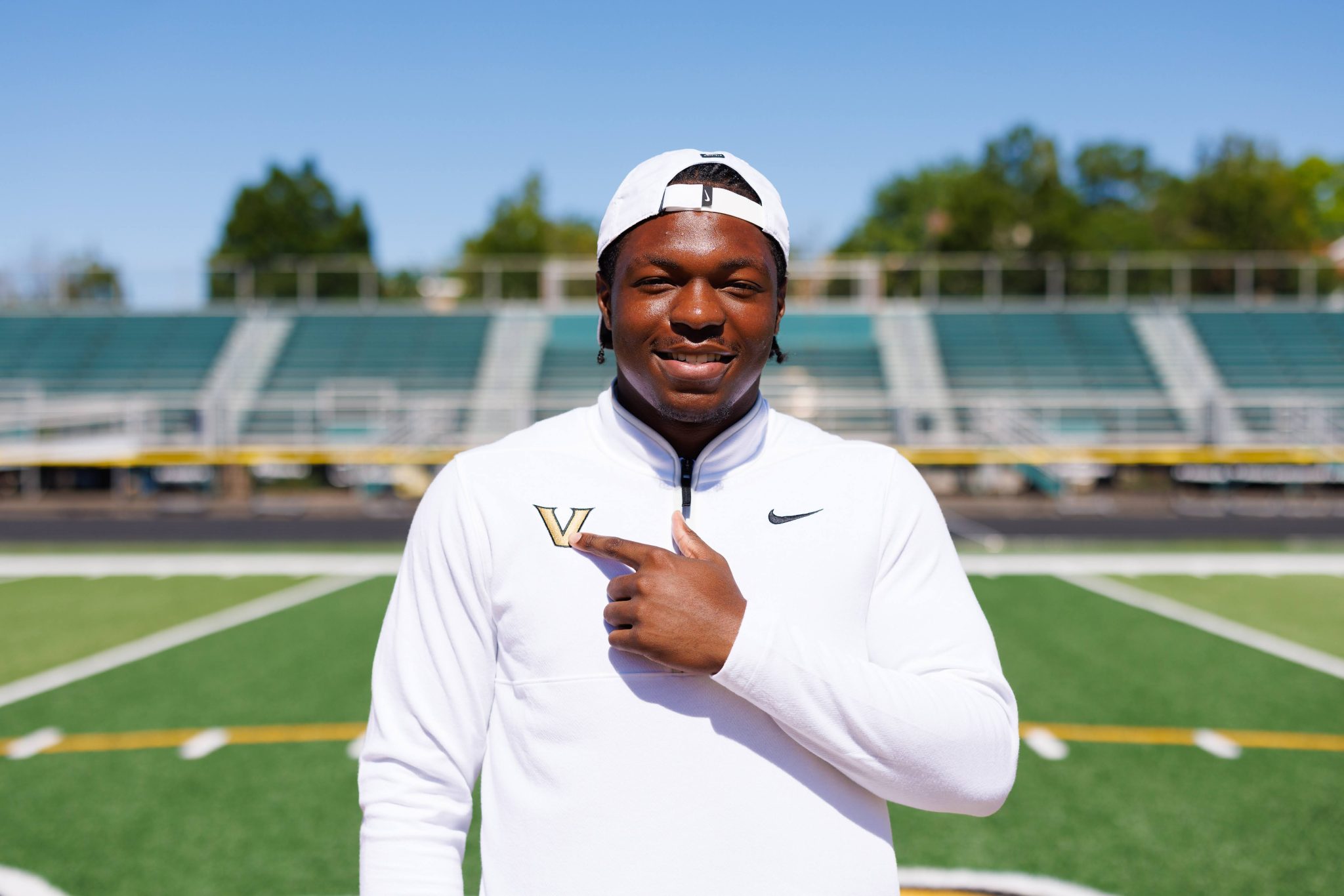 Adekunbi Adetayo proudly shows off the logo of where he will play college football. 