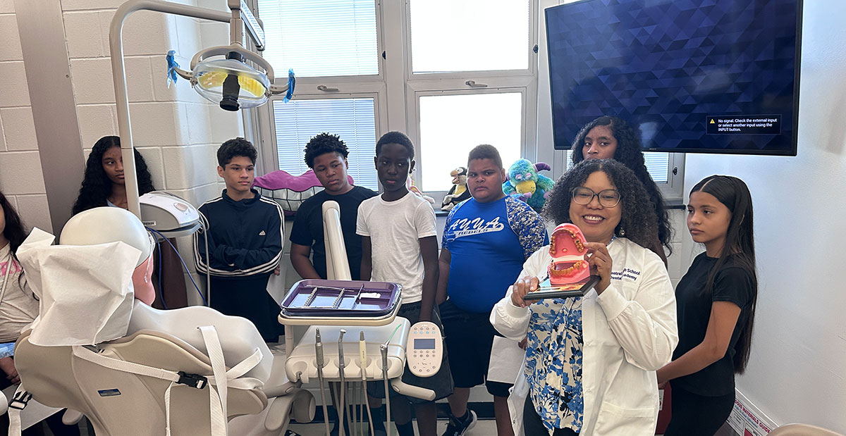Sylvia Bryson, teacher of dental assisting and a registered dental hygienist, shows off a model of a mouth while leading a group of students on a tour of Central High School’s Dental Academy.