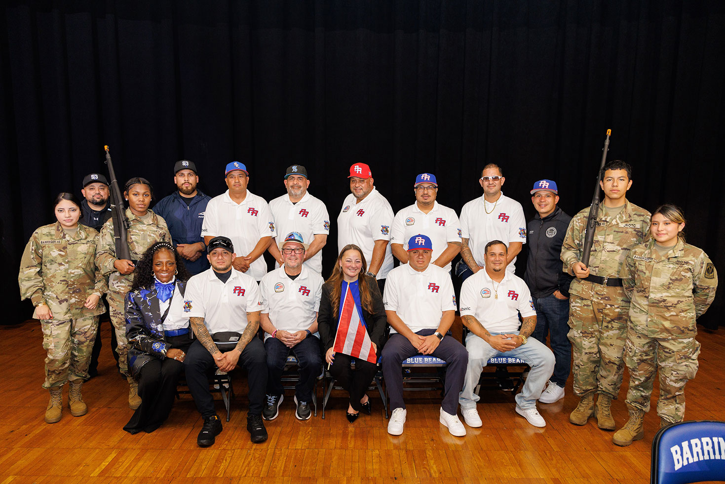 Principal Natasha Pared, center front, and Board Member Louis Maisonave, Jr., standing third from right, pose with nine police officer from Puerto Rico, members of the Barringer High School Junior ROTC program, and Barringer High School staff.