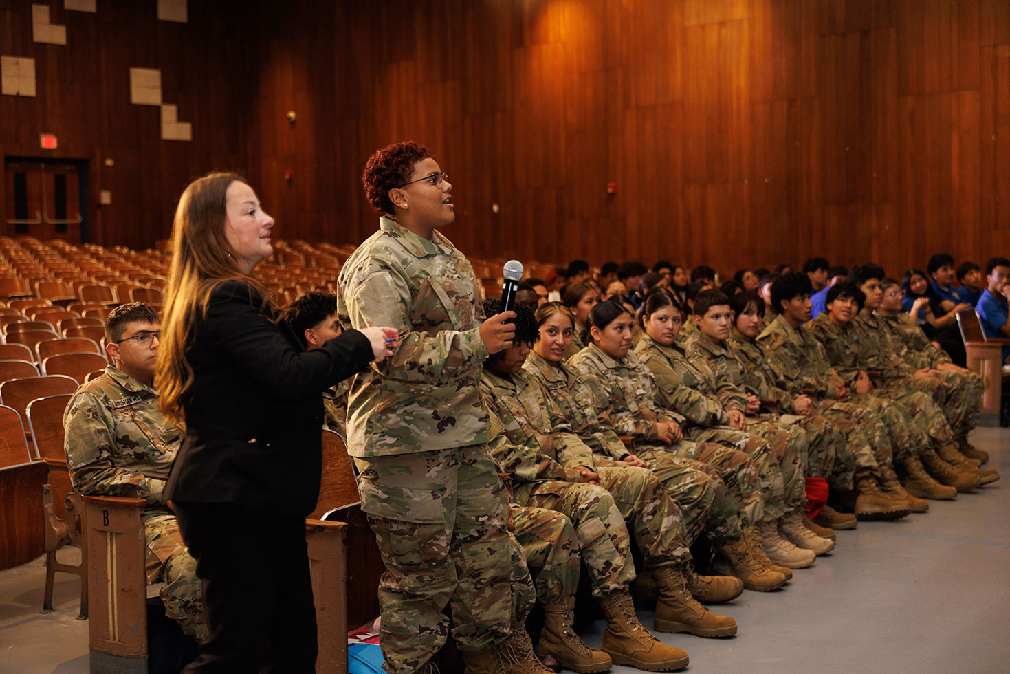 A member of the Barringer High School Junior ROTC program asks a question of the nine police officers from Puerto Rico who spoke at a special assembly.